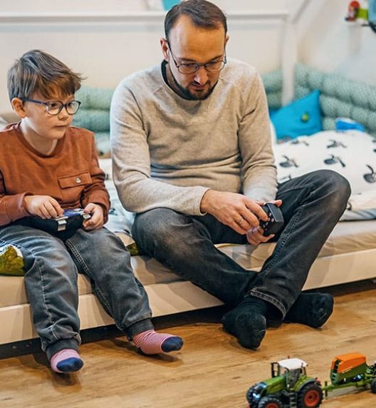 Man and Boy Sitting on Bed — Wearable Technology - Mollii Exopulse